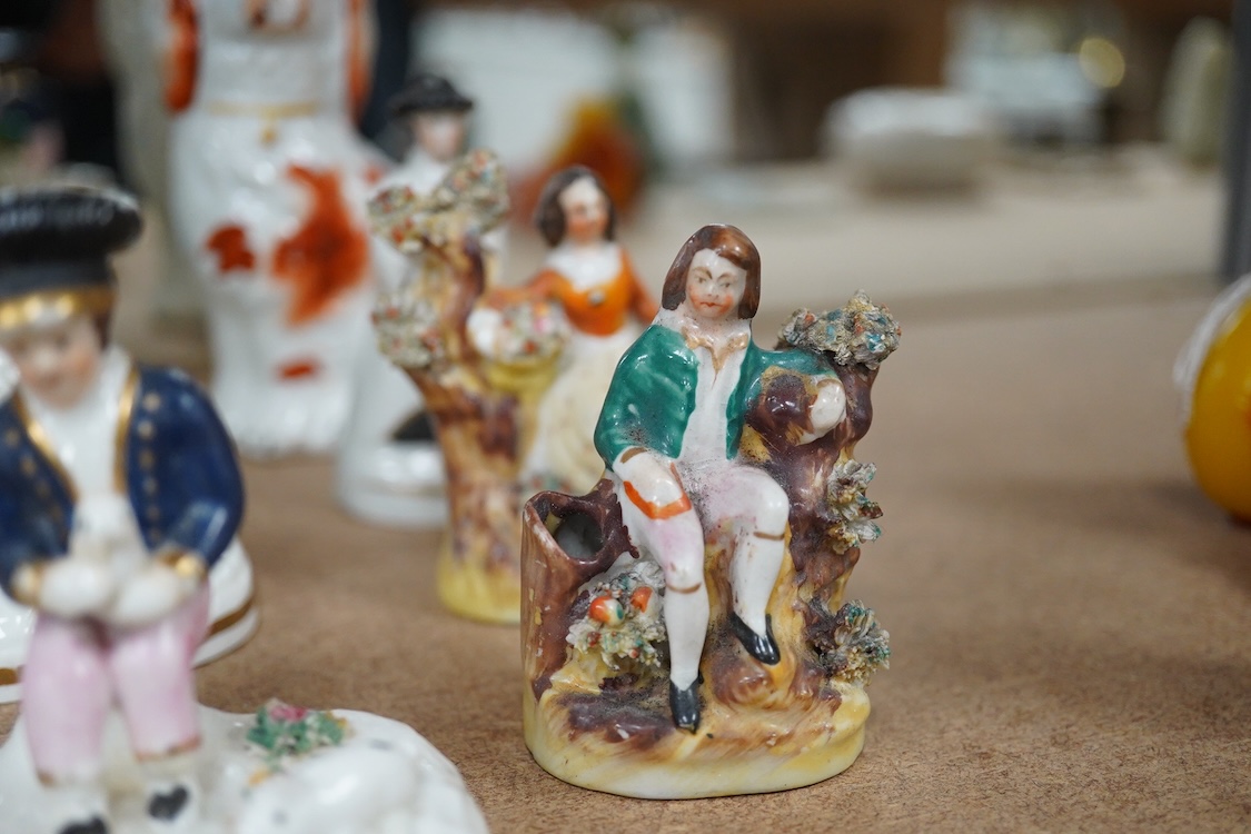 A collection of 19th century and later Staffordshire figures, mostly figural examples, including a pair a rare pair of porcelain seated figures with rabbits and a candle extinguisher, largest 15cm high (15)